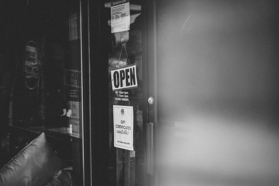 An Open sign hanging in a storefront door